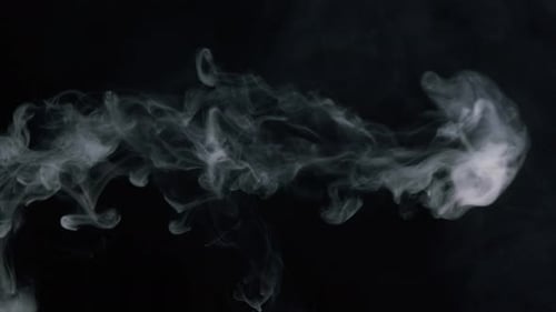 Gros plan des anneaux de fumée fumant le narguilé ou la cigarette dans le studio sombre Vue côté de souffler des bouffées de