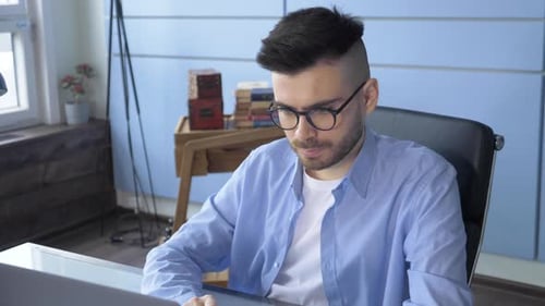 Man Typing And Working On Laptop in cozy home office