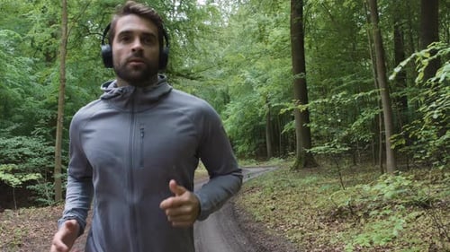 Handsome Athlete Jogging Through Forest