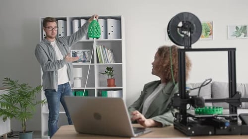 Modern Technologies for Home Improvement Young Man and Woman Print Lamp Shades on a 3D Print in a