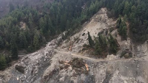 Luftaufnahme fliegt über einen Erdrutsch in Nepal in Richtung unbefestigter Straße