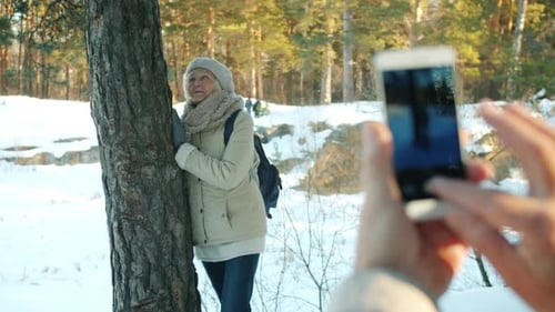 Elderly Woman Posing for Smartphone Camera Outdoors in Park on Winter Day