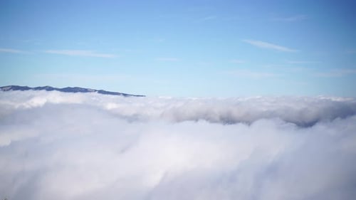 Luftaufnahme von dichtem, nebelartigem, wunderschönem Wolkenmeer und Berggipfeln über den Wolken