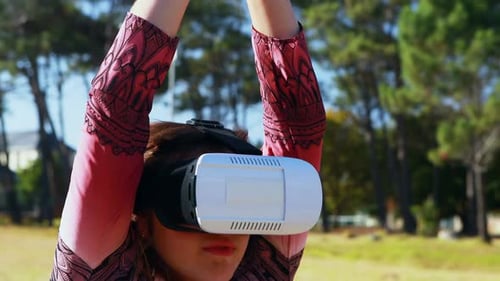 Woman Wearing VR Headset Outside Practicing Yoga