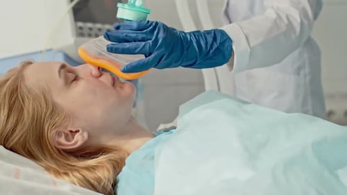 Patient Receives Oxygen Mask in Hospital Bed