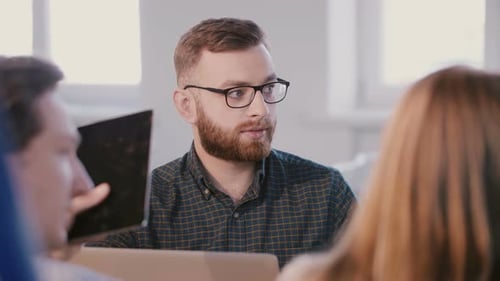 Coworkers Discussing at Table in Office
