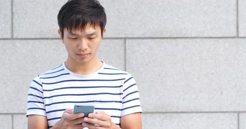 Young Man Using Mobile Phone in Urban Setting