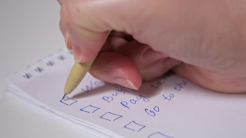 Hand Checking Off Items on a To-Do List