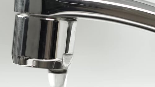 Water Dripping From Chrome Bathroom Faucet Close Up