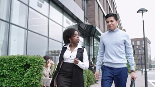 Asian Office Worker Walking in Downtown and Talking with African Businesswoman
