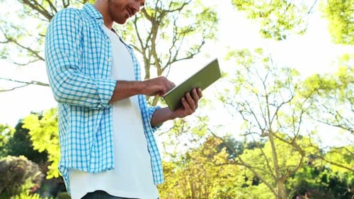 Mann benutzt digitales Tablet im Park
