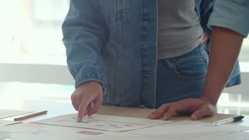 Person Analyzing Charts in an Office Setting