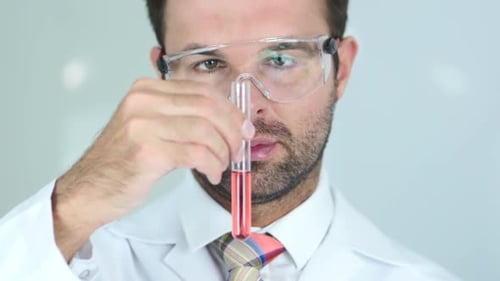 Close Up of Scientist Studying Red Chemical Solution in Test Tube