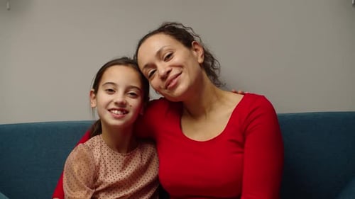 Mother and Daughter Sitting Together Smiling