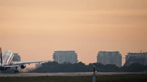Urban Landscape at Sunrise in the Morning in Which a Passenger Plane Takes Off