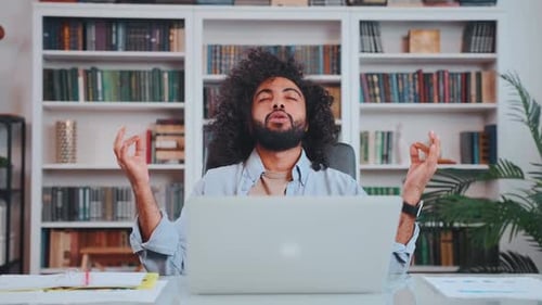 Young Arabian Man Office Worker Does Breathing Exercises Meditation Sits at Desk