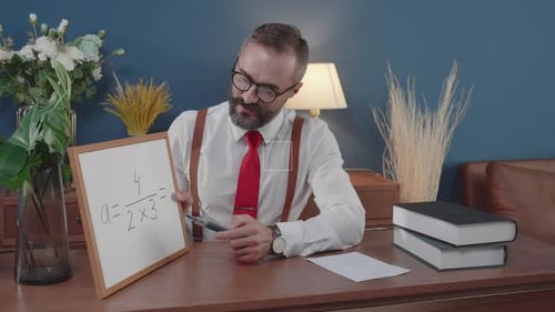 Man Teaching Math at Desk with White Board