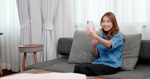 Woman Recording Video with Smartphone on Sofa