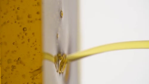 Vertical video: pouring olive oil into a glass