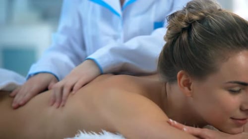 Schöne junge Frau, die sich mit Handmassage im Beauty Spa Closeup entspannt