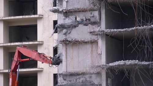Destroying Old Concrete House Using Mechanical Arm of Bulldozer on Construction Site