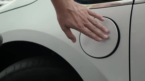Man Unplugs Electric Car Charging Cable During Day