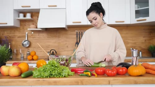 Woman Prepares Salad in Bright Kitchen at Home