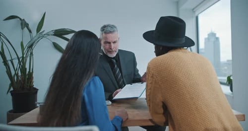 Caucasian agent speaking with customers in the office