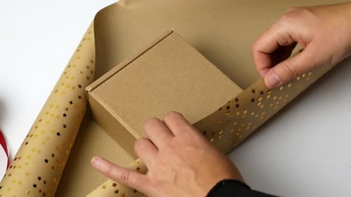 Hands Wrapping Box With Star Paper