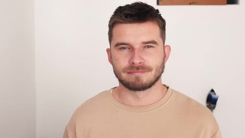 Porträt eines glücklichen jungen kaukasischen Mannes, der vor der Kamera lächelt