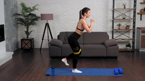Woman Exercising with Resistance Band in Living Room