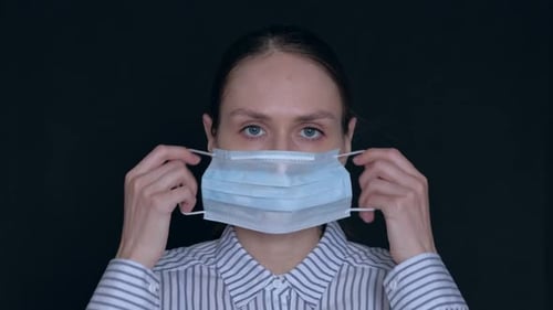 Woman Puts On a Surgical Mask Against Black