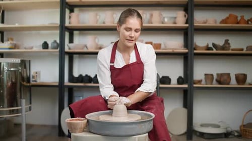 Woman Shaping Clay on a Pottery Wheel