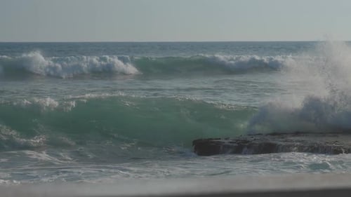 Huge Ocean Waves Roll on Beach Against Blue Sky Slow Motion