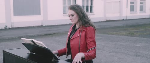 Woman Plays Piano Outdoors in City