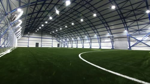 Soccer Field Covered with Lush Turf Under Semicircular Roof