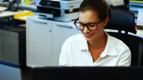 Woman Using Smartphone at Desk in Bright Office