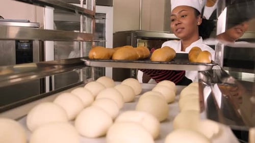 Chef Putting Bread in Oven in Bakery