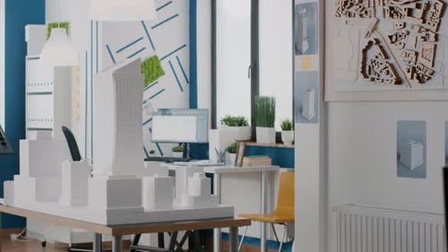 Leeres Büro mit Gebäudemodell und Werkzeugen zum Entwerfen des Bauplans für ein städtisches Projekt