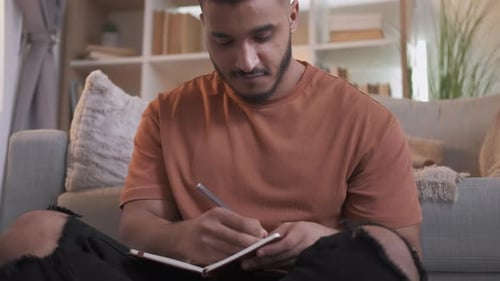 Man Journaling on Floor in Natural Light