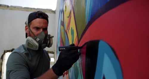Artist Creating Colorful Mural with Black Marker