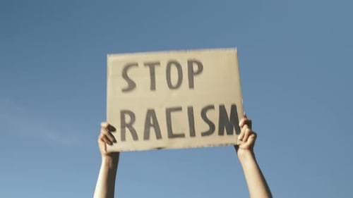 Hand Holding Sign Reading Stop Racism