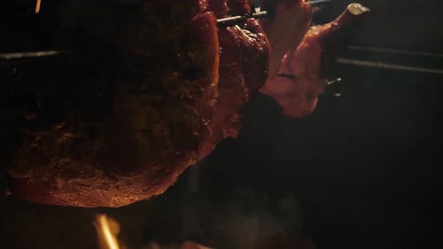 Großes Stück Fleisch am offenen Feuer und einige Schweinestücke gegrillt beim historischen Mittelalterfest