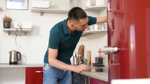 Young Adult Man Cleaning Kitchen Countertop