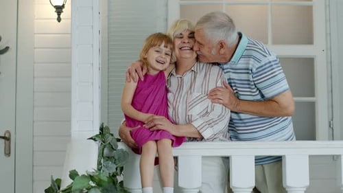 Happy Grandparents and Grandchild on Suburban Home Porch