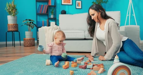 Mother and Baby Play with Toys on Carpet