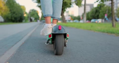 Woman starting a ride on electric scooter. Legs on an electric scooter.