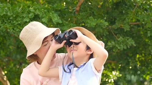 Mother and Child Looking Through Binoculars in Park