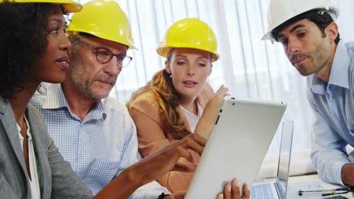 Team of Colleagues Reviewing Construction Plans on Tablet