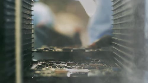 Techniker, der eine Leiterplatte in einer Computerfabrik hält. 4K.
